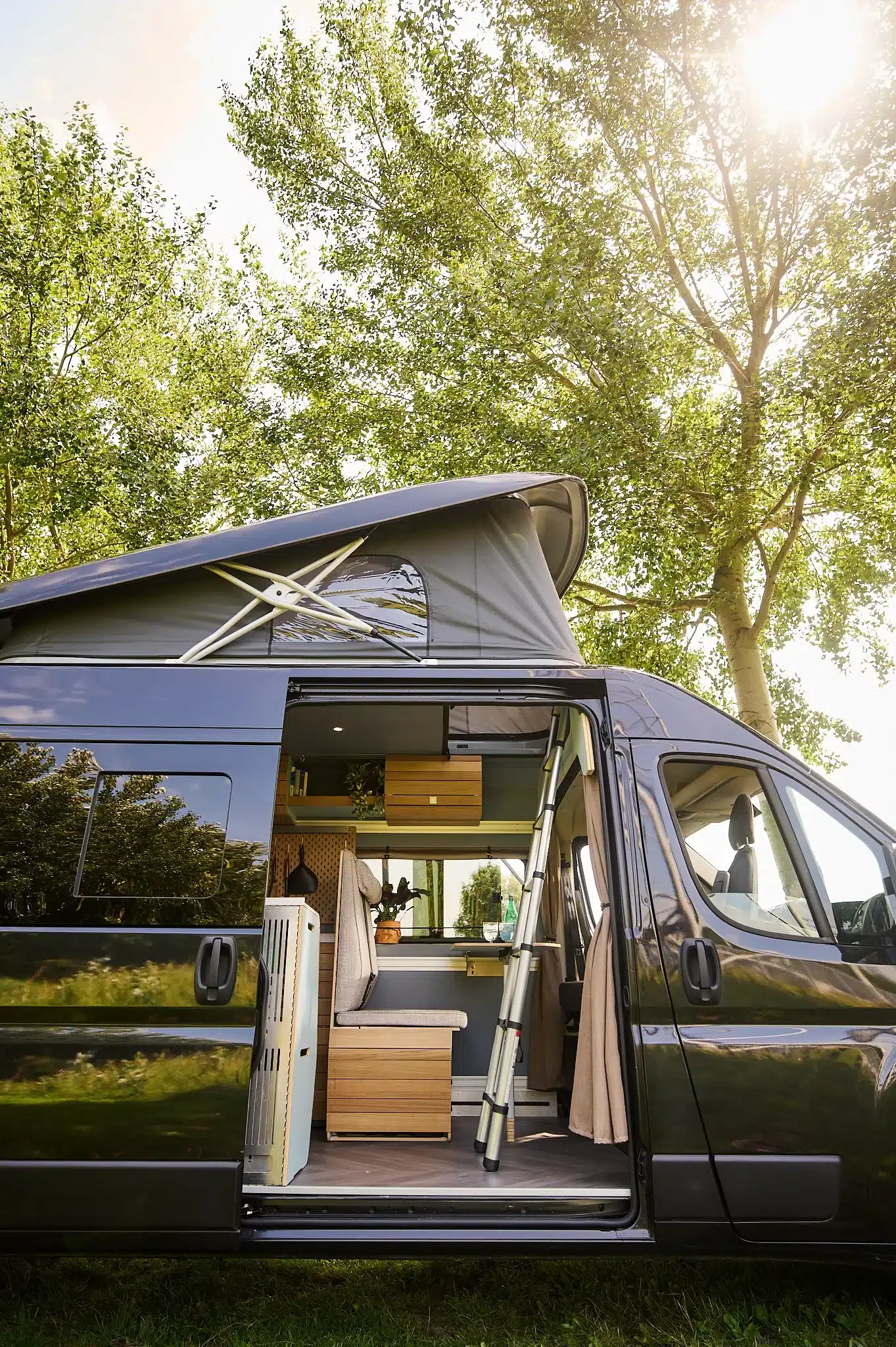 VAN-Jorn Family Campervan mit geöffnetem Aufstelldach und Blick ins flexible, familienfreundliche Interieur.