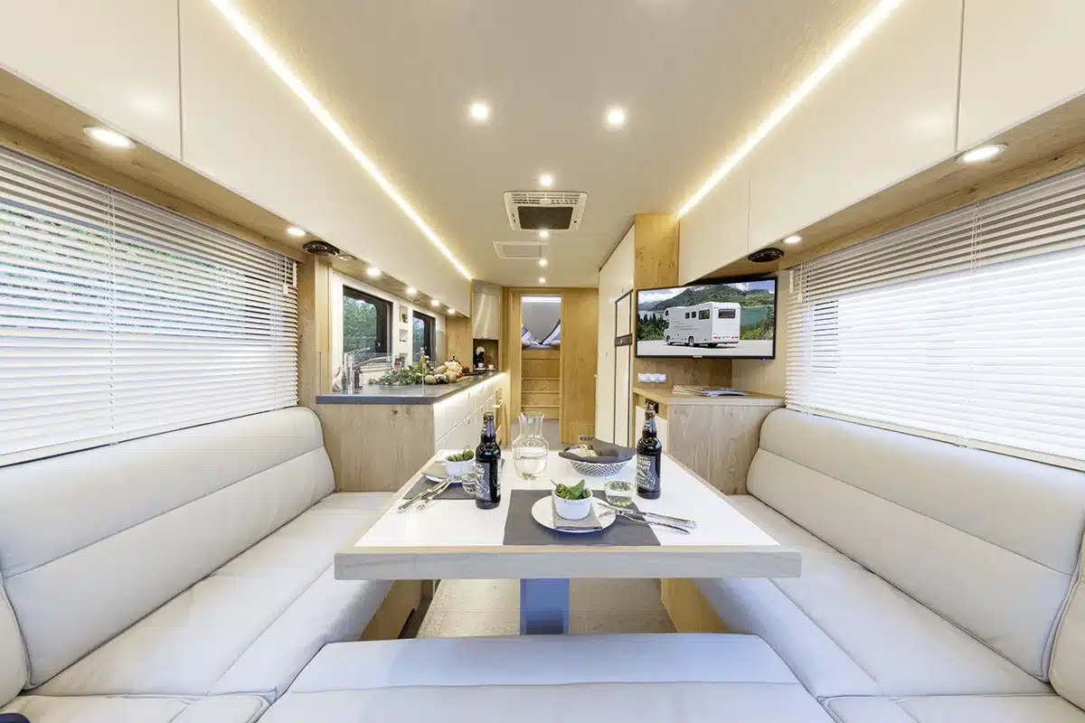 Innenansicht des VARIO Alkoven Reisemobils mit stilvoller Sitzgruppe, Esstisch und moderner Küche