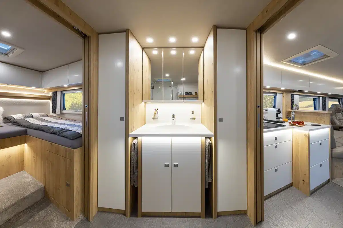 Innenansicht eines VARIO Star 800 Reisemobils mit Schlafzimmer, Bad und Küche in hellen Echtholz- und Weißtönen.