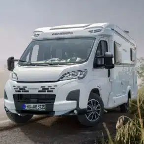 WEINSBERG CaraCompact Reisemobil steht auf einer Landstraße, umgeben von Natur