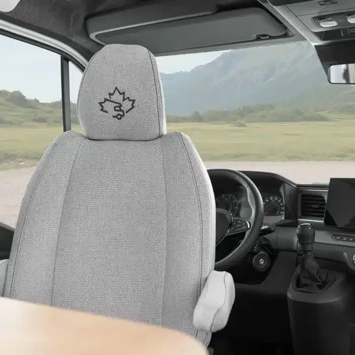 Fahrersitz und Cockpit des Ahorn Camp T 690 mit Lenkrad, Schaltgetriebe und Berglandschaft durch die Frontscheibe