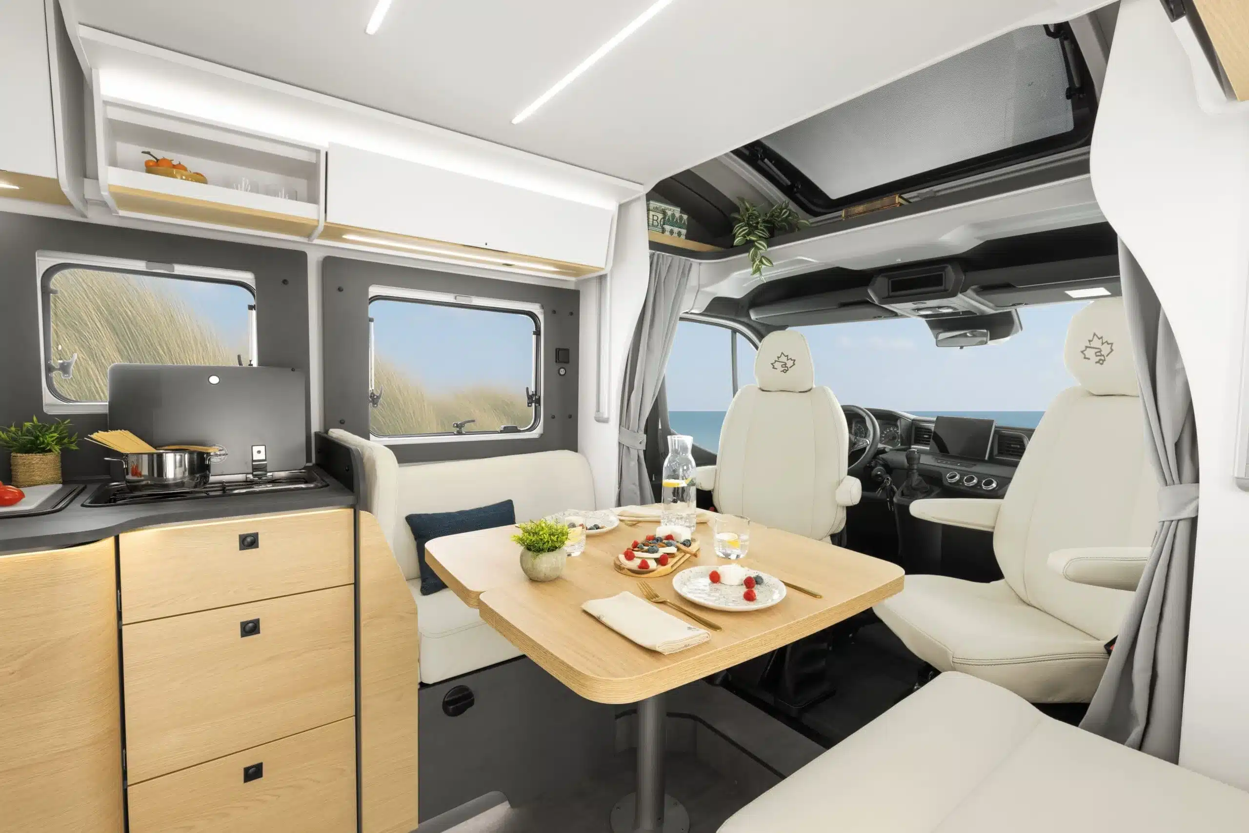 Moderner Wohn- und Essbereich mit Dinette, Küche und Fahrersitzen im Ahorn Camp TQ 740 Wohnmobil