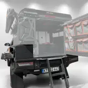 Toyota Land Cruiser 79 mit AluBlack Flatbed, geöffneten Stauboxen und Heckleiter