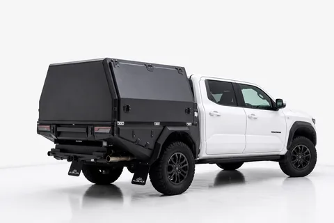 Weißer Toyota Tacoma mit schwarzem AluBlack Flatbed und geschlossenem Canopy