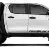 Seitenansicht eines Pick-ups mit AluBlack Flatbed Umbau für modulare Stauraum- und Camping-Lösungen.