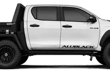 Seitenansicht eines Pick-ups mit AluBlack Flatbed Umbau für modulare Stauraum- und Camping-Lösungen.