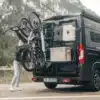 Bike Carrier Swing Fahrradträger am Fahrzeugheck mit aufgeladenen Fahrrädern bei geöffneter Schwenkfunktion vor Bergkulisse