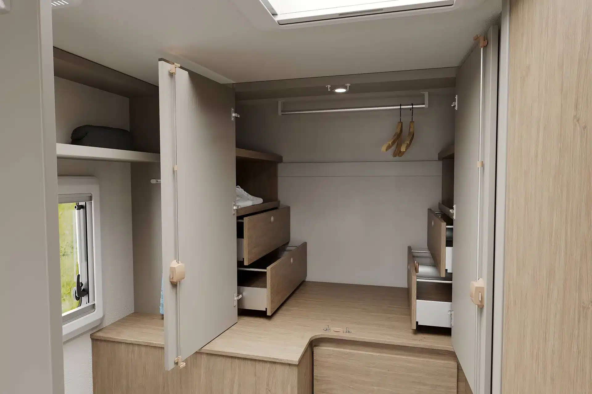 Geräumiger begehbarer Kleiderschrank mit offenen Türen und Schubladen im Wohnmobil Carado T335 EDITION27