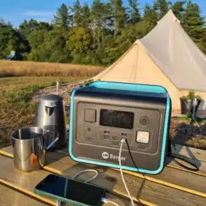 Berger Energy Powerstation BEPS 800 mit angeschlossenem Ladekabel auf einem Campingtisch vor einem Zelt