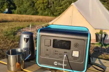 Berger Energy Powerstation BEPS 800 mit angeschlossenem Ladekabel auf einem Campingtisch vor einem Zelt