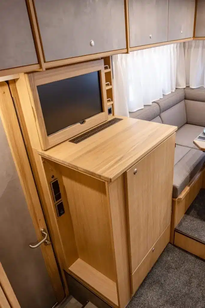 TV-Möbel und Teil der Rundsitzgruppe aus Holz im Innenraum des DOPFER 402 A Reisemobils.