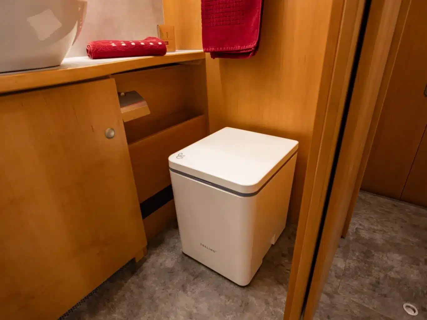 Moderne Trockentrenntoilette im Bad des DOPFER 422 A Reisemobils, umgeben von Holzmöbeln und Boden in Steinoptik.