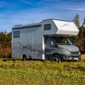 DOPFER 432 A Alkoven-Reisemobil auf einer Wiese, aufgebaut auf Iveco Daily.