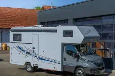 Außenansicht des DOPFER 492 A Reisemobils mit Alkoven vor moderner Halle