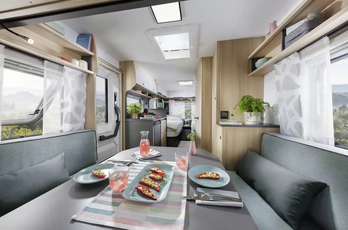 Innenraum eines Fendt-Caravan APERO mit Sitzgruppe, Küche, Essplatz und Holzdekor