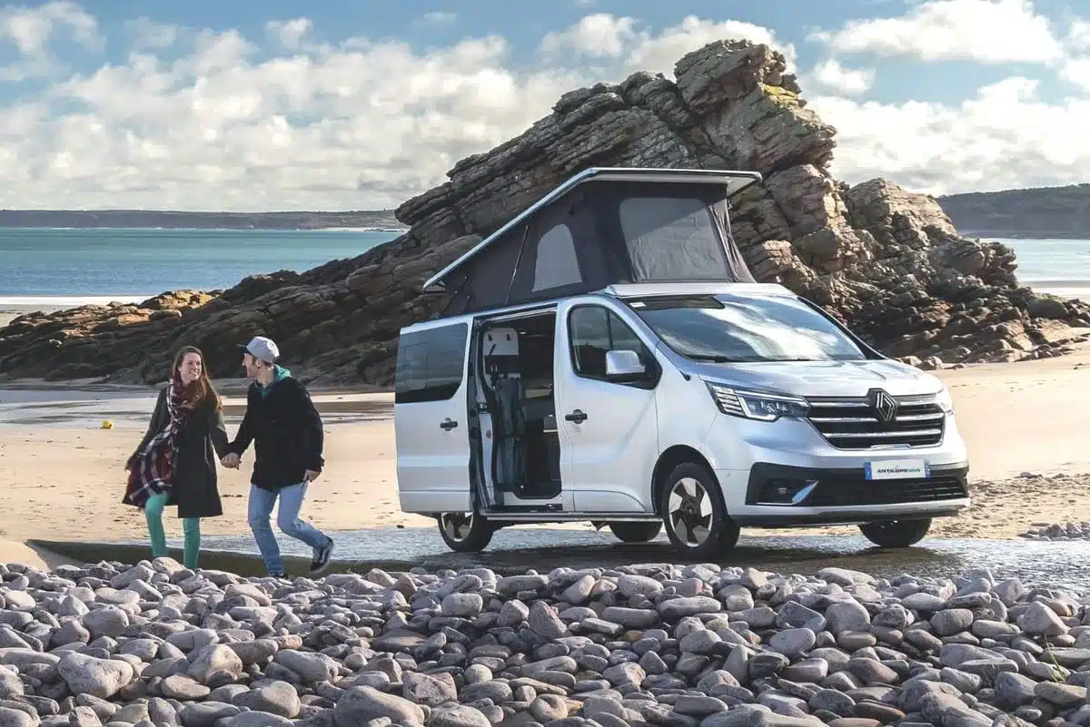 Flex Confort PLUS Campervan mit Aufstelldach am Strand, ein Paar läuft davor.
