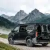 Ford Custom 4x4 Campervan von Wavecamper auf einer Schotterpiste in alpiner Landschaft
