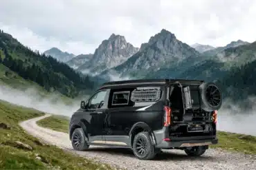 Ford Custom 4x4 Campervan von Wavecamper auf einer Schotterpiste in alpiner Landschaft
