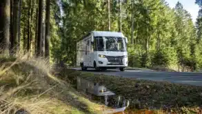 Weißes FRANKIA FINAL EDITION Reisemobil auf einer Waldstraße