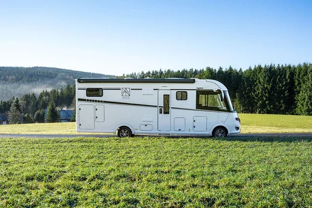 Weißes integriertes FRANKIA Reisemobil der FINAL EDITION auf einer grünen Wiese