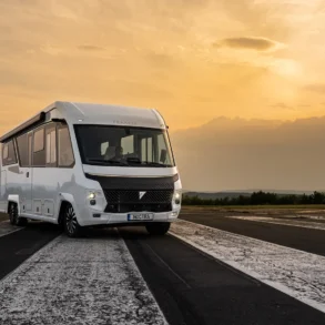 Weißer FRANKIA NOCTRA Liner als integriertes Luxuswohnmobil auf einer Fahrbahn bei Sonnenuntergang
