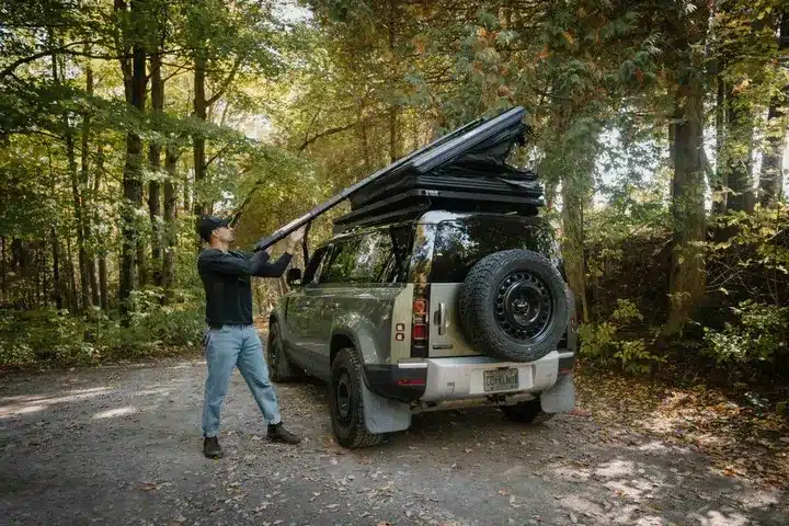 Geöffnetes Go Overland Voyage Hybrid-Dachzelt auf einem Geländewagen im Wald