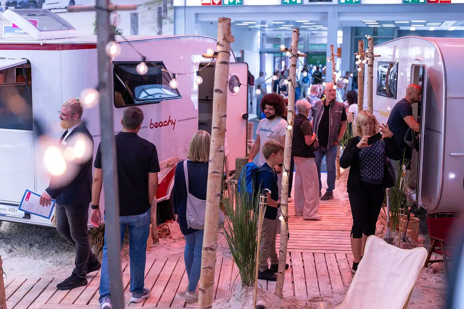Menschen schlendern durch den BEACHY-Bereich des Caravan Salon 2026 und betrachten die ausgestellten Hobby Wohnwagen.