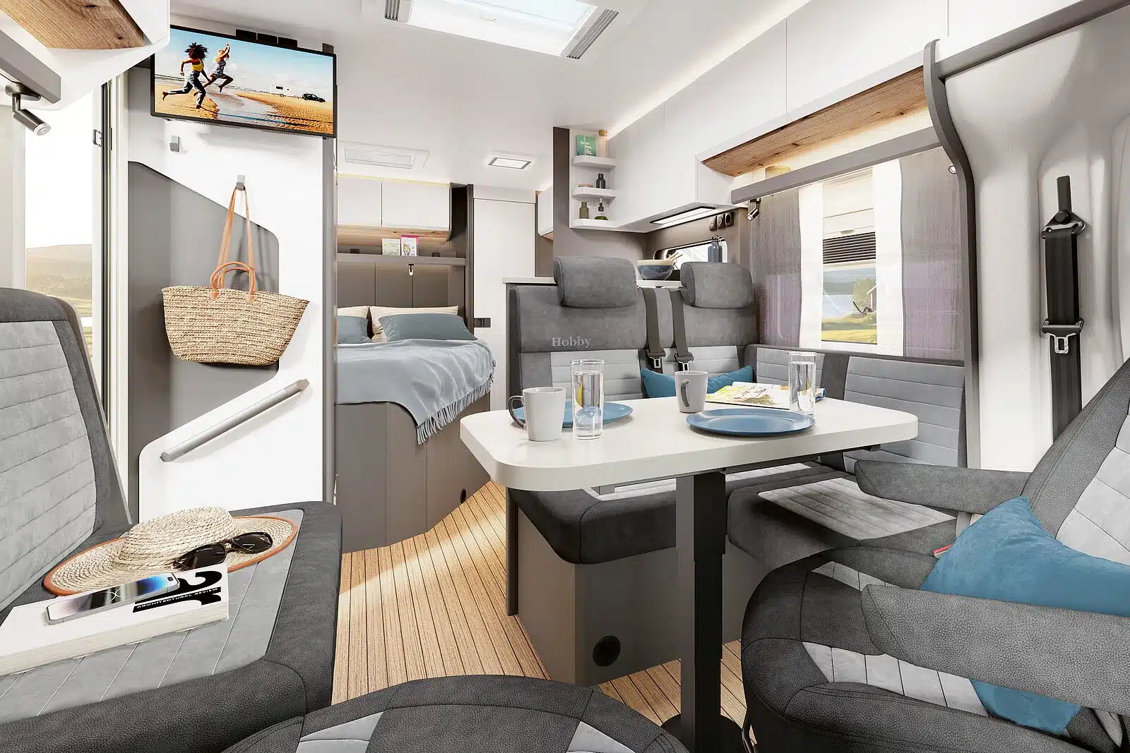 Innenansicht eines Hobby Wohnmobils mit hellem Interieur, Sitzgruppe und maritimem Boden in Yachtdesign.