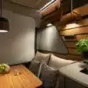 Innenraum des Hymer Venture S mit Sitzgruppe, Bambustisch, Küchenzeile und dimmbarer Beleuchtung