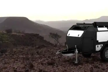 Ein i-p2 Off Road Caravan steht in einer felsigen, halbwüstenähnlichen Landschaft bei Sonnenuntergang