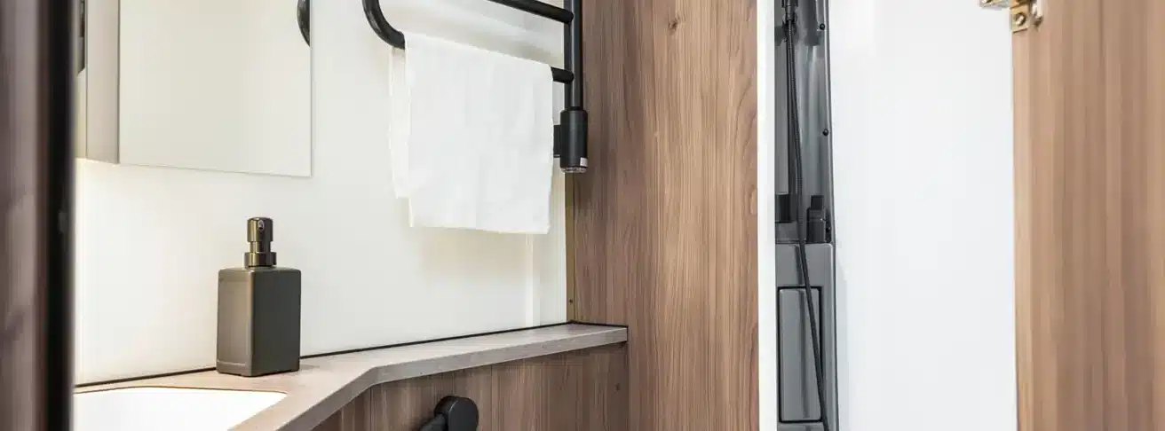 Badezimmer im KABE Royal 600 XL mit Handtuchhalter, Waschbecken und Holzdekor