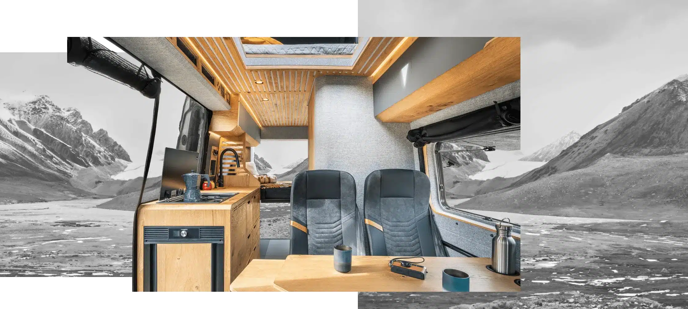 Blick in den Innenraum eines Vannado Karakorum Campervans mit Holzverkleidung, Küchenzeile, Sitzplätzen und Heckbett.