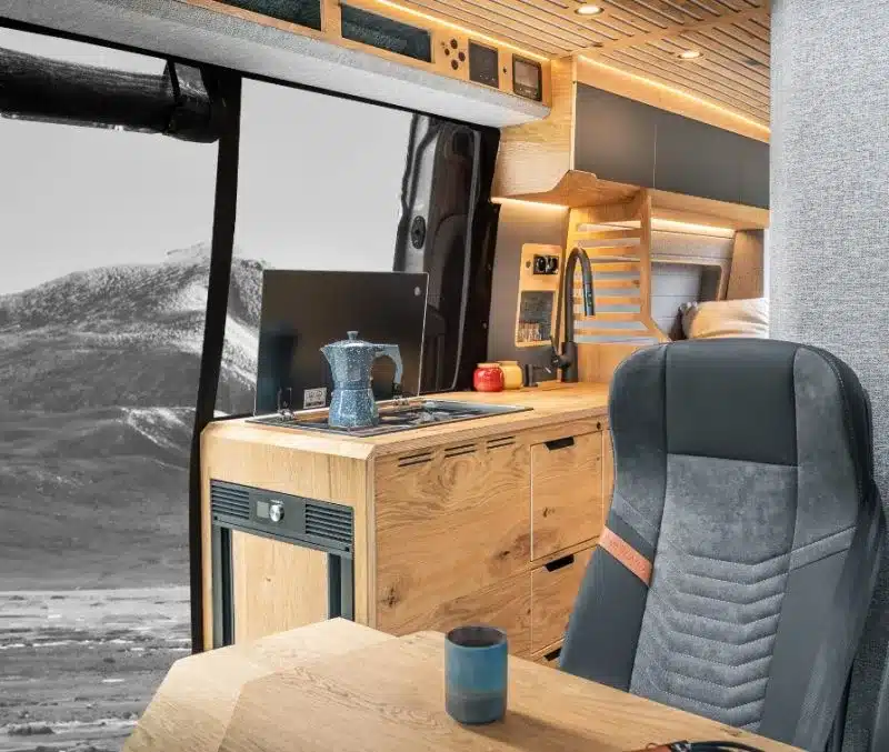 Innenansicht eines Vannado Karakorum Campervans mit Küchenzeile, Sitzbereich und moderner Ausstattung.
