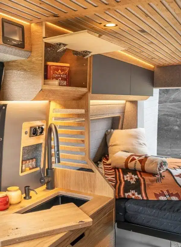 Innenausstattung eines Vannado Karakorum Campervans mit Holzdesign, Küche, Spüle und Schlafbereich