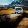 Weißes vollintegriertes Malibu Wohnmobil auf einer Bergstraße vor einer alpinen Felslandschaft