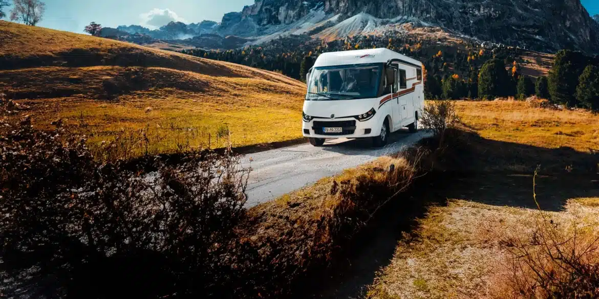 Weißes vollintegriertes Malibu Wohnmobil auf einer Bergstraße vor einer alpinen Felslandschaft