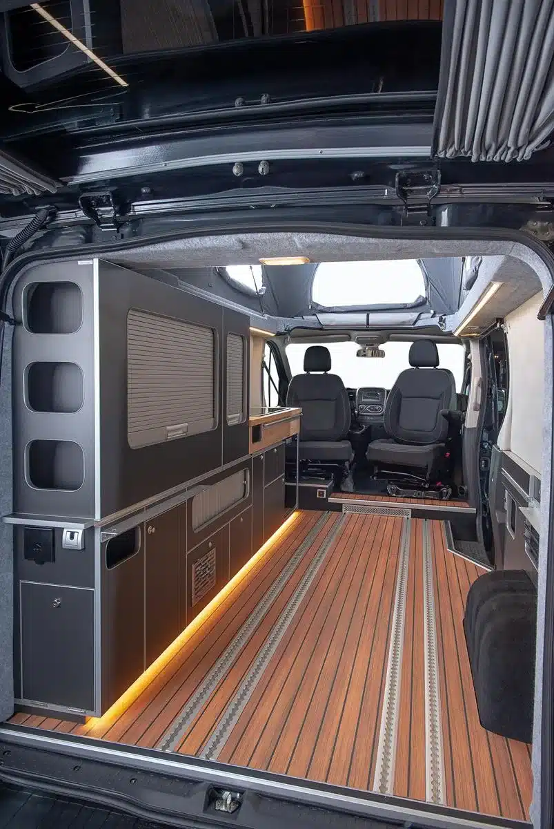 Innenraum eines Renault Trafic Flex mit Camperausbau, Küchenzeile, Holzfußboden und Aufstelldach
