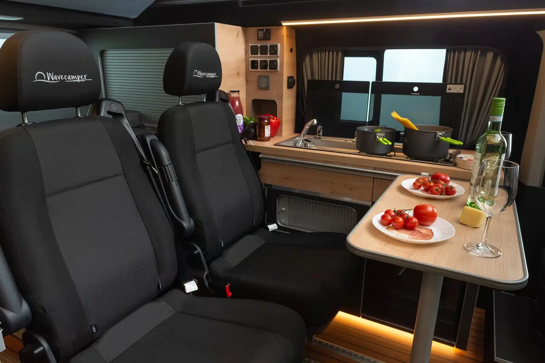 Innenraum des Renault Trafic Flex Campervans von Wavecamper mit Sitzen, Küchenzeile und Esstisch