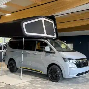 Grauer Rhön Camp THE NEW ULTIMATE Camper-Van mit aufgestelltem Schlafdach in einer Halle