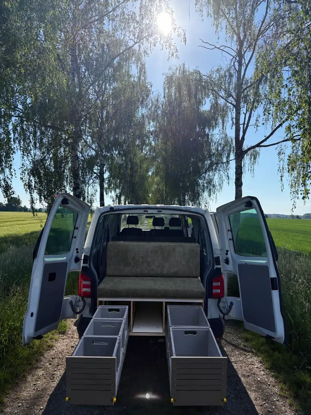 S KISTL Bench lite Campingbox mit Sitzbank und geöffneten Auszugboxen im Heck eines Vans