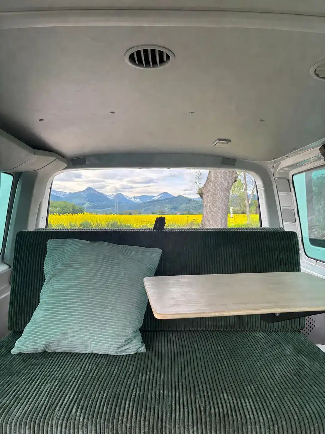 S KISTL Bench Campingbox als gepolsterte Sitzbank mit Tisch im Van vor einer Berglandschaft