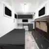 Innenansicht eines Sport Caravan 360 mit Klappbett, Schränken und moderner Campingausstattung.