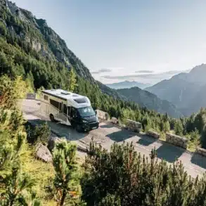 Sunlight Teilintegriertes Adventure Reisemobil auf einer kurvenreichen Bergstraße vor einer alpinen Landschaft