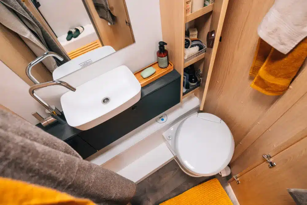 Modernes Bad im Sunlight Teilintegrierten UNLTD Reisemobil mit Waschbecken, Toilette und Stauraum.