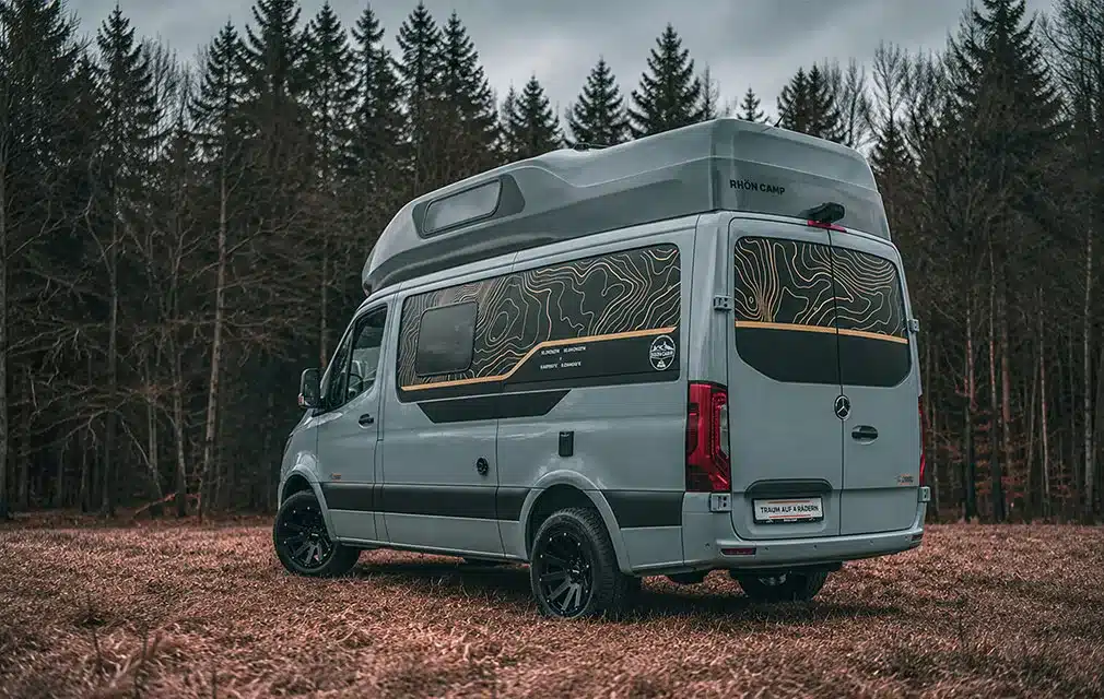 Grauer Rhön Camp The Core Campervan mit Hochdach steht auf einem Waldweg