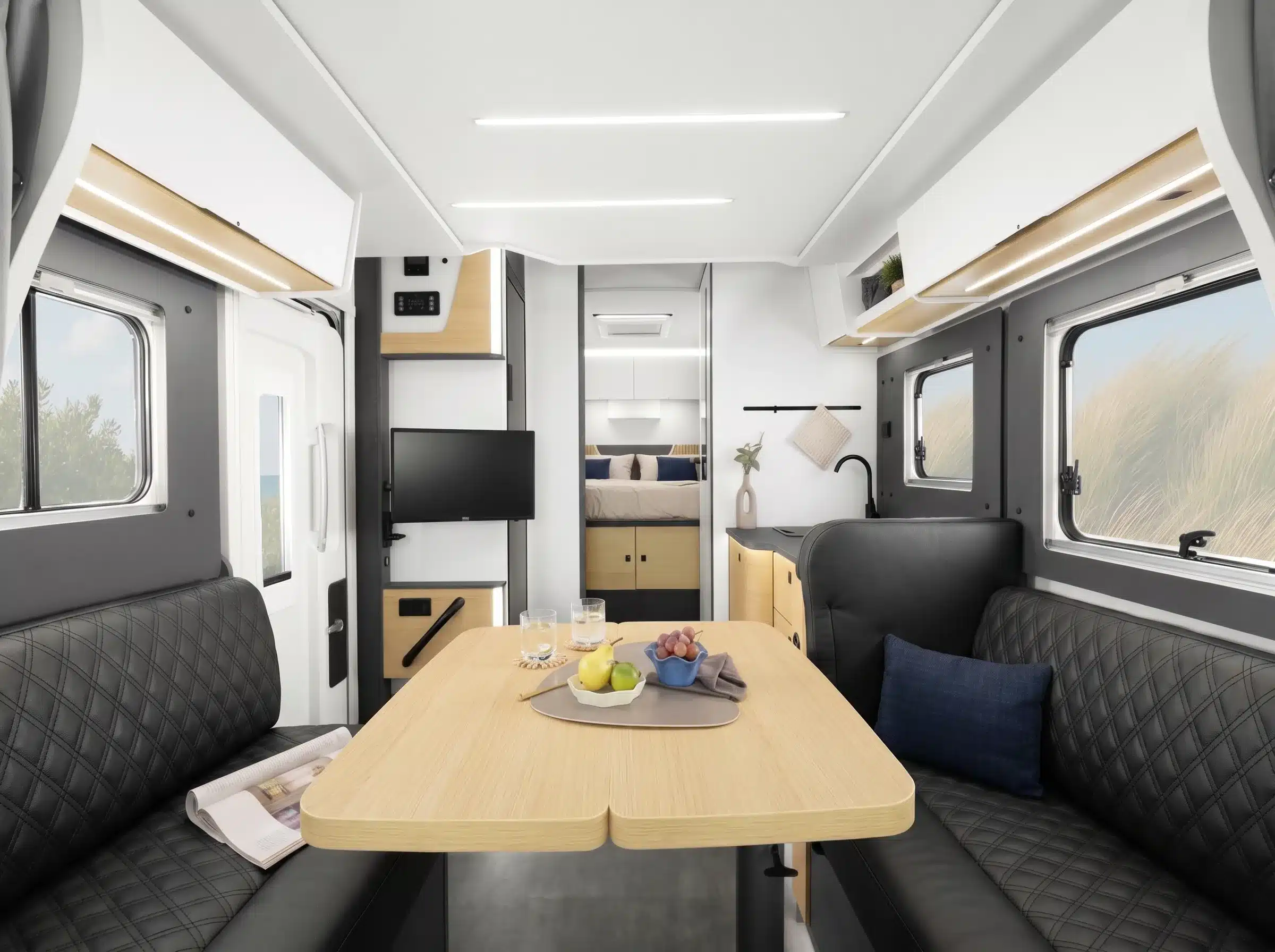 Innenraumansicht des Ahorn Camp TQ 740 Eclipse mit Sitzgruppe, Esstisch, Küche und Queensbett im Heck.