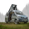Vannado Ontario Campervan, silbergrau, mit geöffnetem Aufstelldach, im Wald auf einer Wiese geparkt. Seitentür offen, moderner Camper-Ausbau sichtbar.