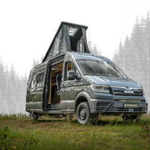 Vannado Ontario Campervan, silbergrau, mit geöffnetem Aufstelldach, im Wald auf einer Wiese geparkt. Seitentür offen, moderner Camper-Ausbau sichtbar.