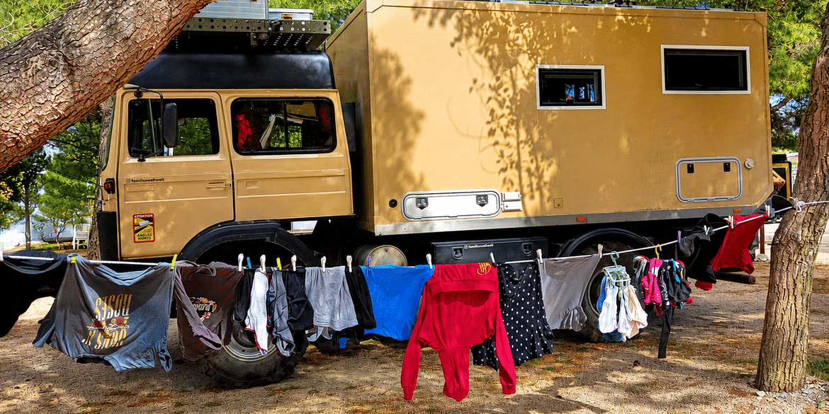 Wäscheleine mit frisch gewaschener Kleidung vor unserem Wohnmobil auf einem Campingplatz