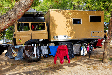 Wäscheleine mit frisch gewaschener Kleidung vor unserem Wohnmobil auf einem Campingplatz